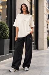 Woman wearing doa off-white oversized tee and relaxed trousers, street style