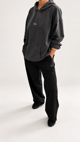 Woman wearing doa oversized hoodie in dark grey styled with doa black relaxed wide-leg trousers